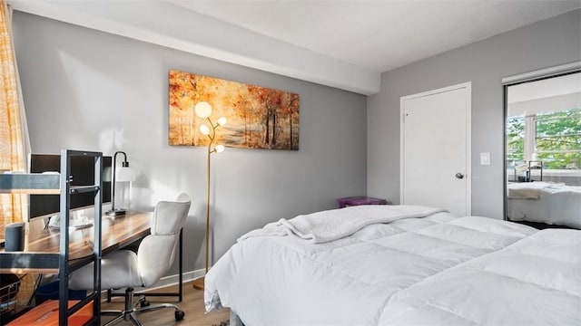 bedroom featuring baseboards and wood finished floors