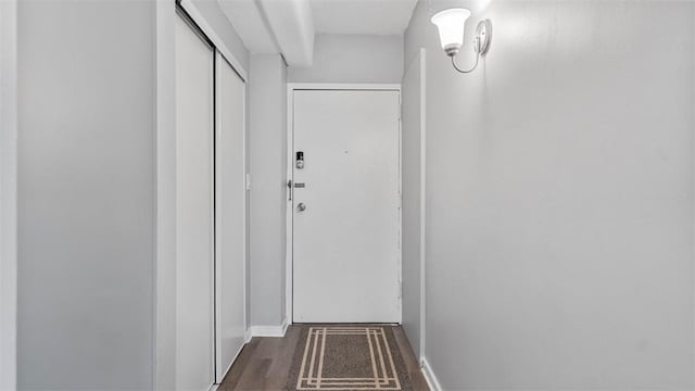 hallway featuring wood finished floors and baseboards