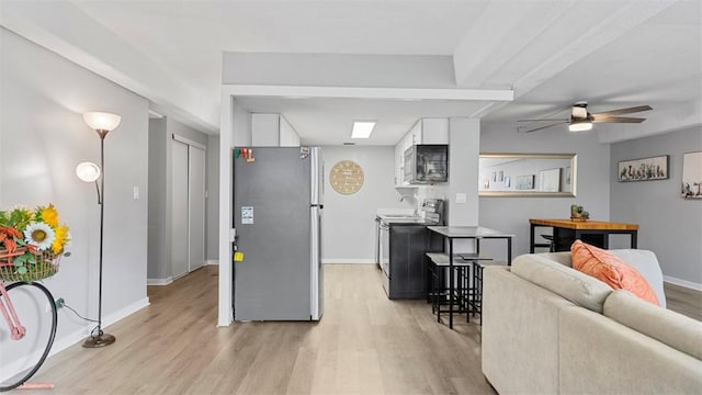 kitchen featuring freestanding refrigerator, light wood-style flooring, white cabinetry, and electric range oven