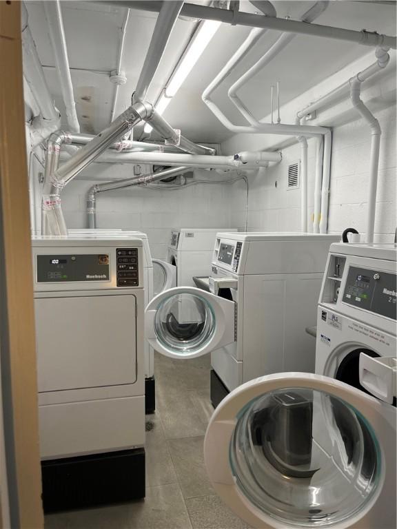 5619 Kentucky Ave Unit 102, Shadyside, PA 15232 - shared laundry room with independent washer and dryer, concrete block wall, and tile patterned floors