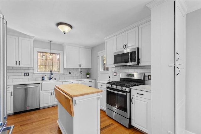 159 Inglewood Dr, Mt Lebanon, PA 15228 - kitchen with white cabinets, stainless steel appliances, a sink, decorative backsplash, and butcher block counters