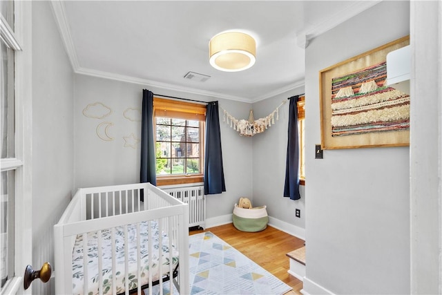 159 Inglewood Dr, Mt Lebanon, PA 15228 - bedroom featuring radiator heating unit, a crib, wood finished floors, ornamental molding, and baseboards
