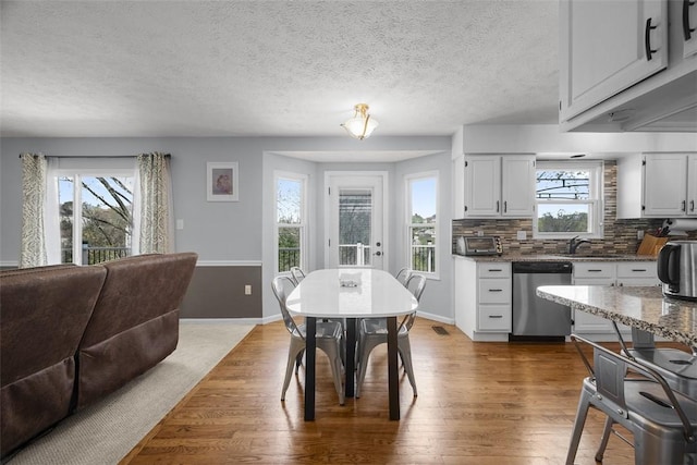 dining space with dark wood finished floors, baseboards, and a textured ceiling