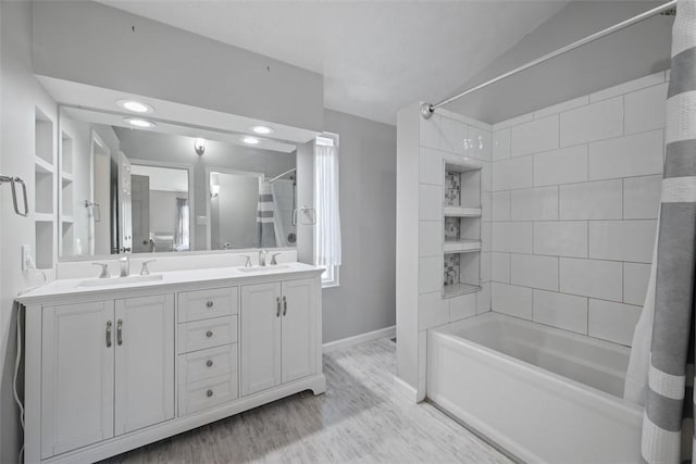 full bathroom featuring wood finished floors, double vanity, tub / shower combination, baseboards, and recessed lighting