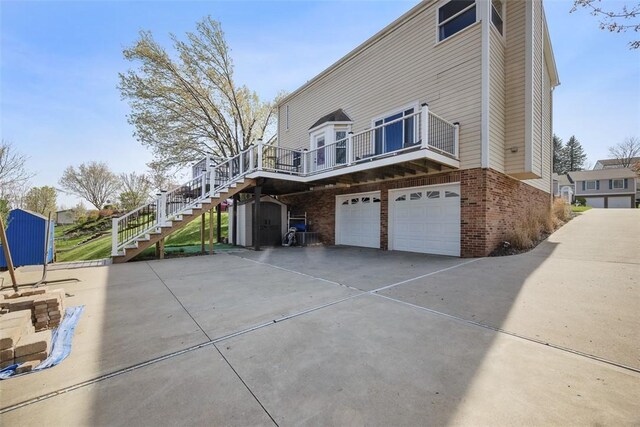216 Briar Path, North Fayette, PA 15126 - view of side of home featuring stairway, brick siding, concrete driveway, a garage, and a shed