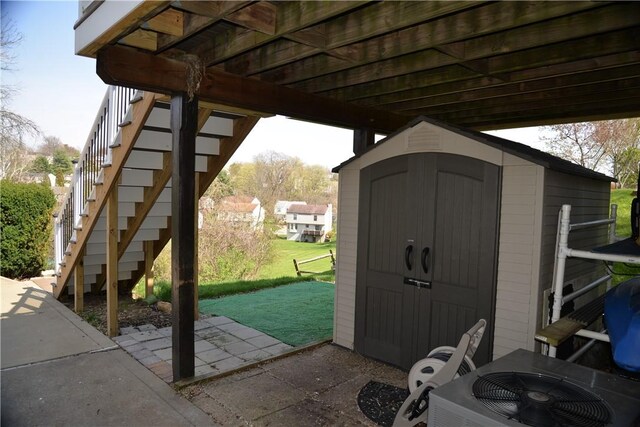 view of shed featuring stairs and central air condition unit