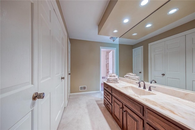 bathroom featuring vanity, baseboards, and recessed lighting