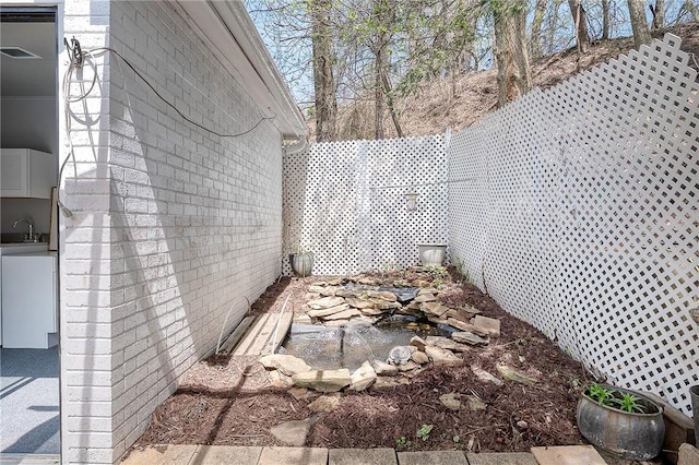 view of side of home with a sink and brick siding