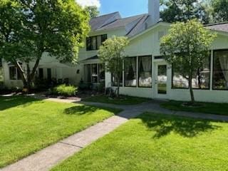 rear view of house with a lawn and a chimney