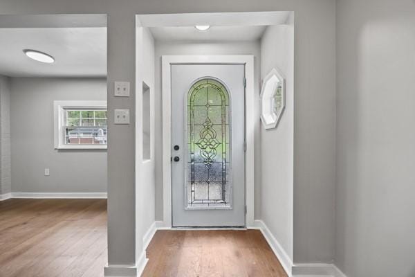 foyer featuring baseboards and wood finished floors