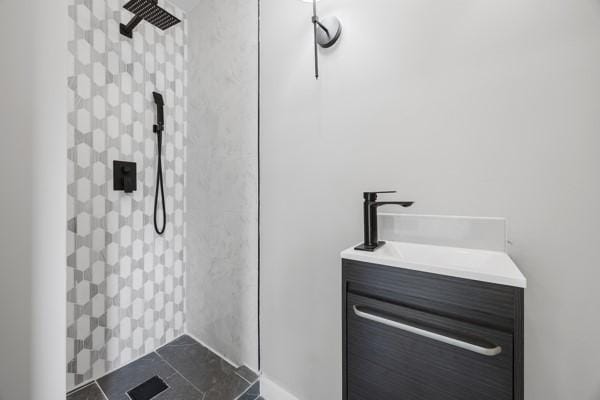 bathroom with tile patterned floors, vanity, and tiled shower