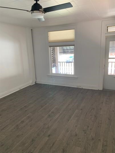 7310 Church St, Swissvale, PA 15218 - unfurnished room with dark wood finished floors, baseboards, and a ceiling fan