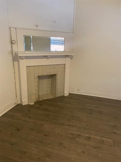7310 Church St, Swissvale, PA 15218 - unfurnished living room with dark wood finished floors, baseboards, and a tile fireplace