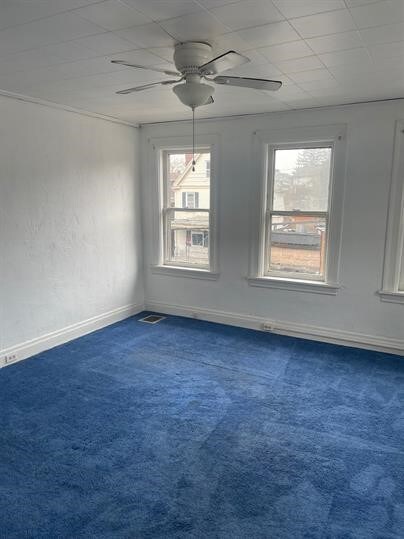 7310 Church St, Swissvale, PA 15218 - unfurnished room featuring dark carpet, visible vents, baseboards, and ceiling fan