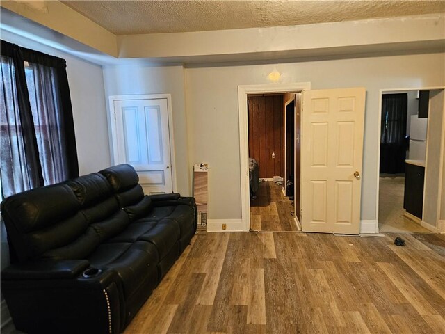 802 10th St, Stowe Twp, PA 15136 - living area with a textured ceiling, wood finished floors, and baseboards