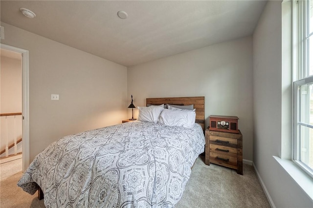 bedroom with baseboards and carpet