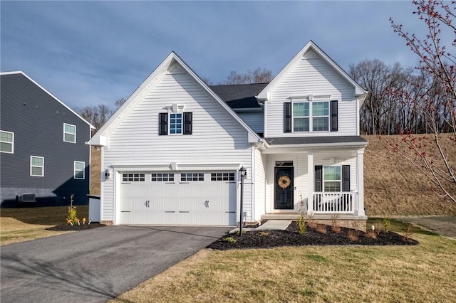 traditional-style home featuring an attached garage, driveway, a porch, and a front yard