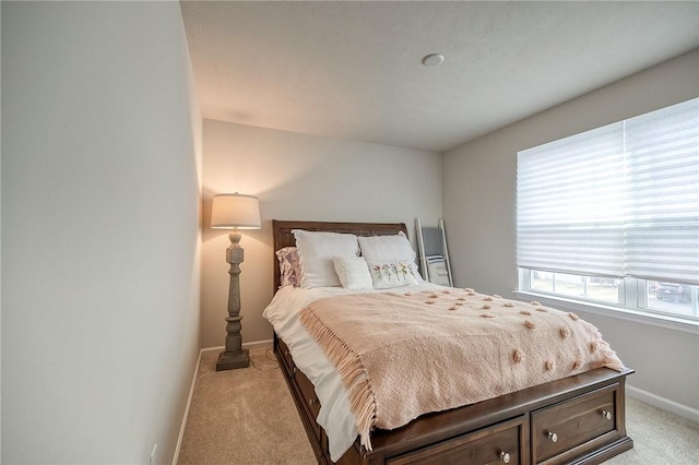 bedroom featuring light carpet and baseboards