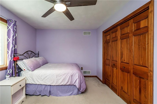 carpeted bedroom featuring baseboards, a ceiling fan, visible vents, and a closet