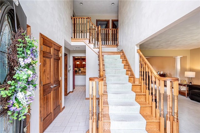 staircase with a high ceiling and baseboards