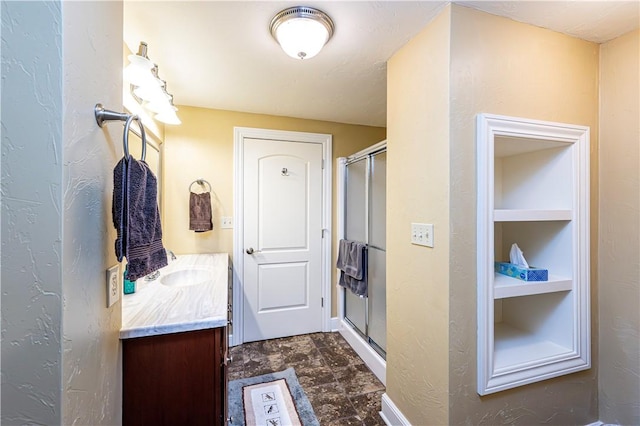 interior space with a shower stall, baseboards, and vanity