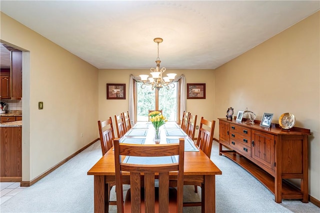 dining room with a chandelier, baseboards, and light carpet