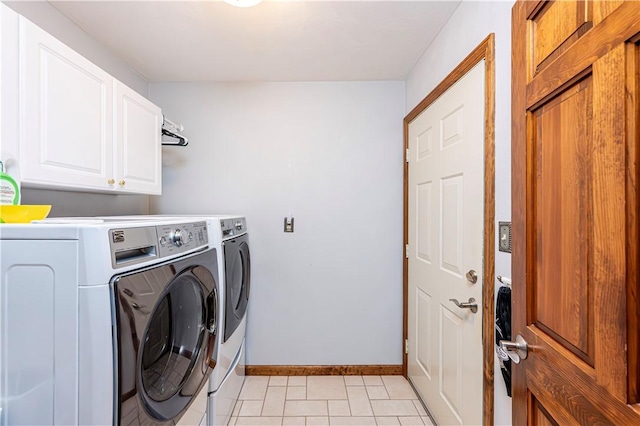 laundry room with cabinet space, light tile patterned floors, baseboards, and washer and clothes dryer