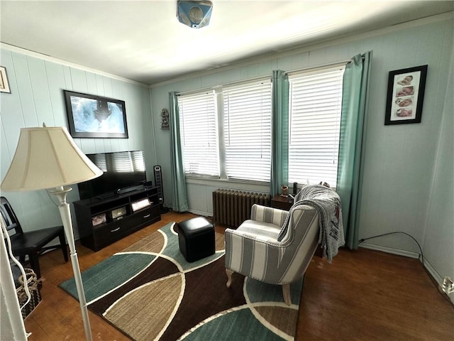 living room with radiator, ornamental molding, and wood finished floors
