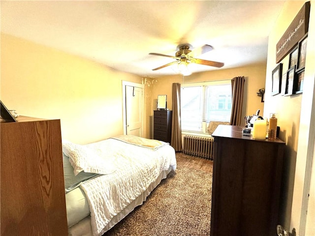 bedroom featuring radiator, wood finished floors, and ceiling fan