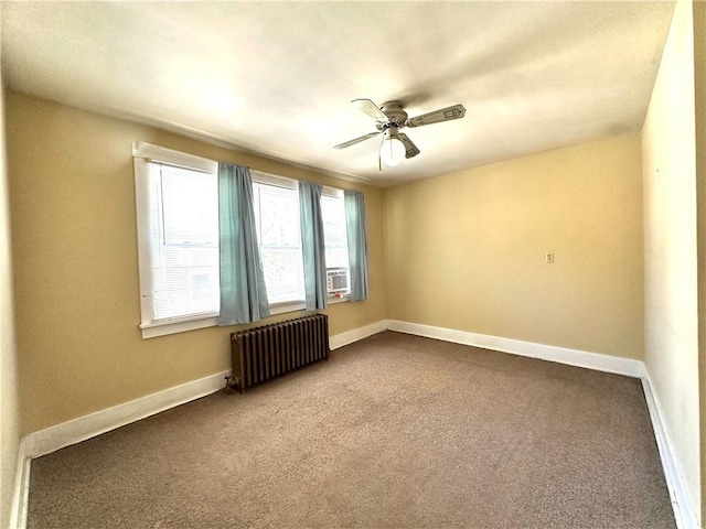 empty room featuring radiator heating unit, dark colored carpet, baseboards, and ceiling fan