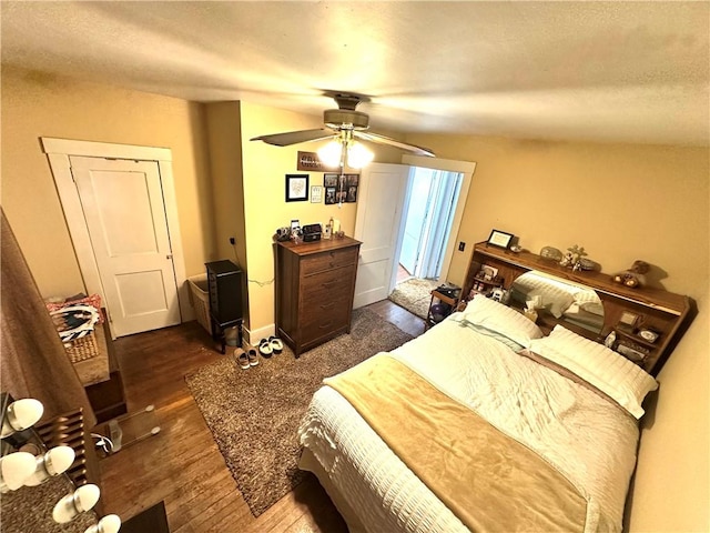 bedroom with ceiling fan and dark wood-style floors