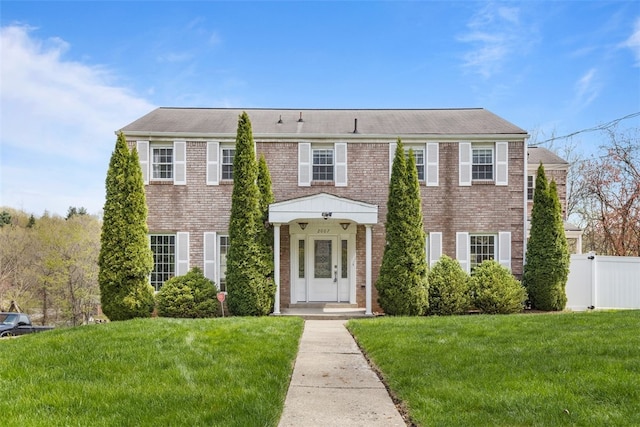 2007 Garrick Dr, Churchill Boro, PA 15235 - colonial house featuring fence, a front lawn, and brick siding