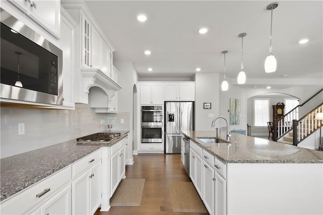 342 Juniper Way, Peters Twp, PA 15317 - kitchen featuring stainless steel appliances, a sink, arched walkways, decorative backsplash, and white cabinetry
