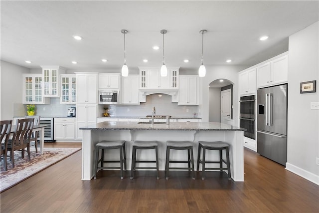 342 Juniper Way, Peters Twp, PA 15317 - kitchen with beverage cooler, stainless steel appliances, a center island with sink, decorative backsplash, and white cabinetry