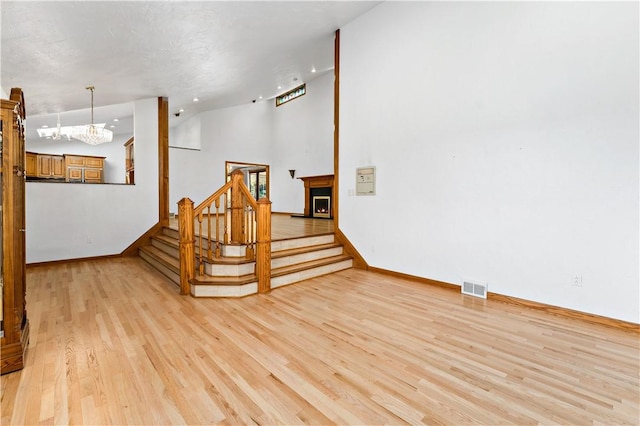 86 Lambeth Dr, Upper St Clair, PA 15241 - unfurnished living room featuring stairs, light wood-style floors, baseboards, a notable chandelier, and visible vents