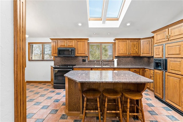 86 Lambeth Dr, Upper St Clair, PA 15241 - kitchen featuring black range with electric stovetop, a sink, a center island, a skylight, and tasteful backsplash