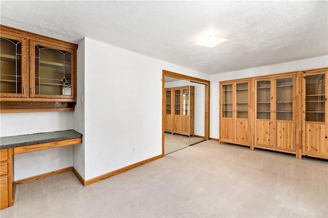 86 Lambeth Dr, Upper St Clair, PA 15241 - empty room with light colored carpet, baseboards, built in study area, and a textured ceiling