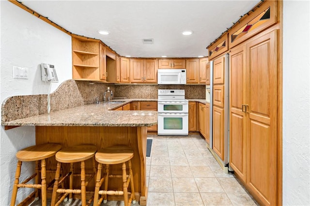 86 Lambeth Dr, Upper St Clair, PA 15241 - kitchen featuring a peninsula, a sink, decorative backsplash, white appliances, and light stone counters