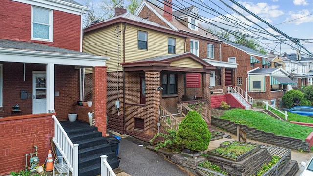 1323 Methyl St, Beechview, PA 15216 - view of front of house with brick siding, covered porch, stairs, and a vegetable garden