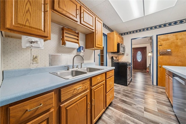 1323 Methyl St, Beechview, PA 15216 - kitchen featuring brown cabinetry, light wood-style flooring, stainless steel appliances, and a sink