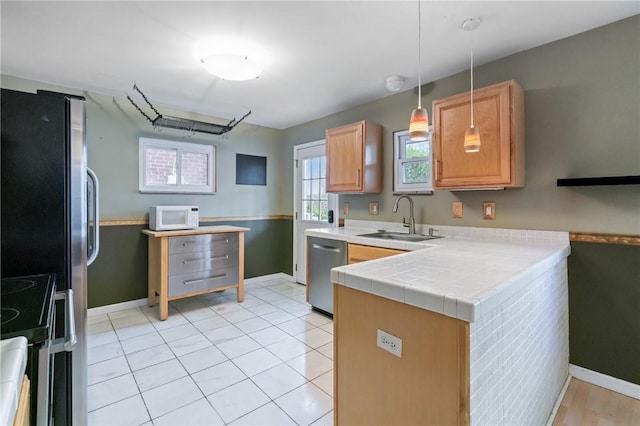 814 Greenfield Ave, Greenfield, PA 15217 - kitchen with a peninsula, a sink, baseboards, decorative light fixtures, and appliances with stainless steel finishes