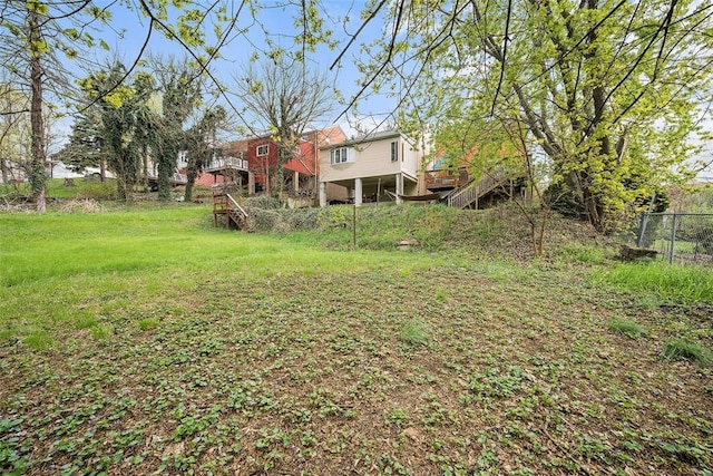 view of yard with stairway, fence, and a deck