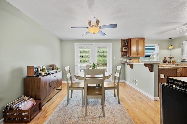 dining space featuring plenty of natural light, a ceiling fan, and light wood-type flooring