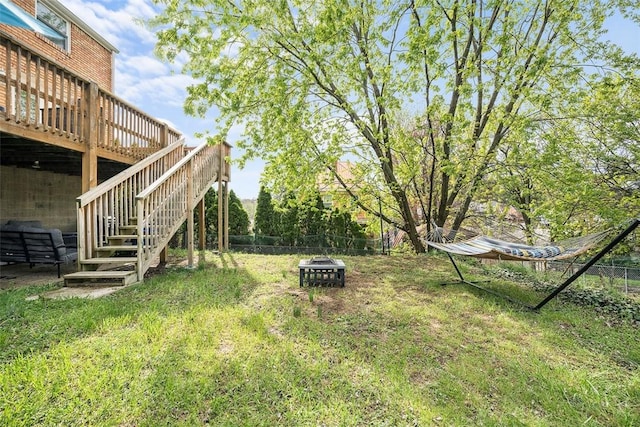 view of yard featuring fence, stairs, an outdoor fire pit, and a deck