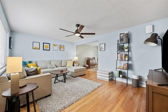 living room with light wood finished floors and ceiling fan