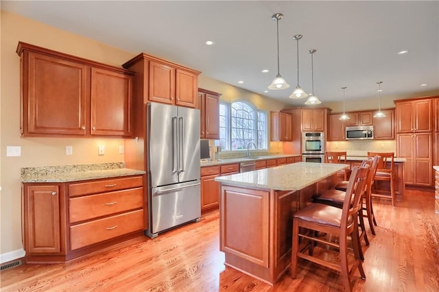 404 Plum Ct, Cranberry Twp, PA 16066 - kitchen with appliances with stainless steel finishes, light wood finished floors, a center island, a breakfast bar, and recessed lighting