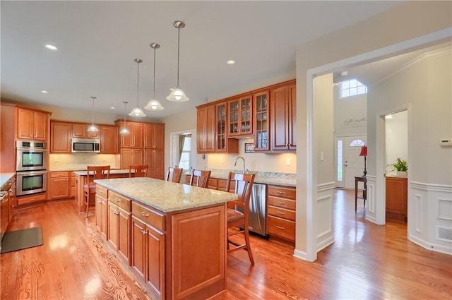 404 Plum Ct, Cranberry Twp, PA 16066 - kitchen with stainless steel appliances, a kitchen bar, a kitchen island, plenty of natural light, and a wainscoted wall