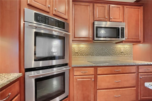 404 Plum Ct, Cranberry Twp, PA 16066 - kitchen featuring stainless steel appliances, backsplash, light stone countertops, and brown cabinets