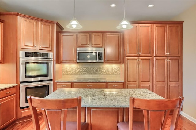 404 Plum Ct, Cranberry Twp, PA 16066 - kitchen featuring stainless steel appliances, backsplash, a breakfast bar area, a kitchen island, and pendant lighting
