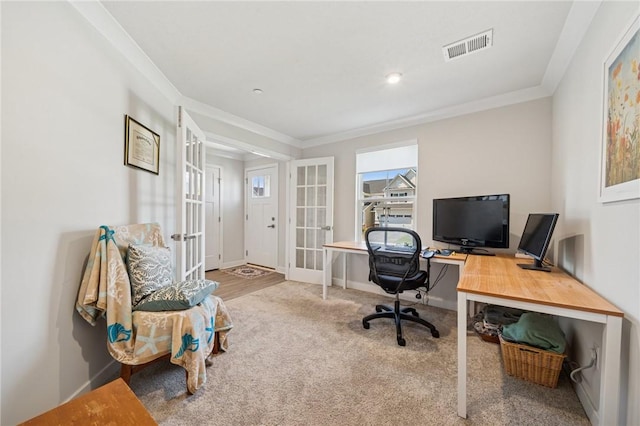 carpeted office space featuring visible vents, baseboards, ornamental molding, and french doors